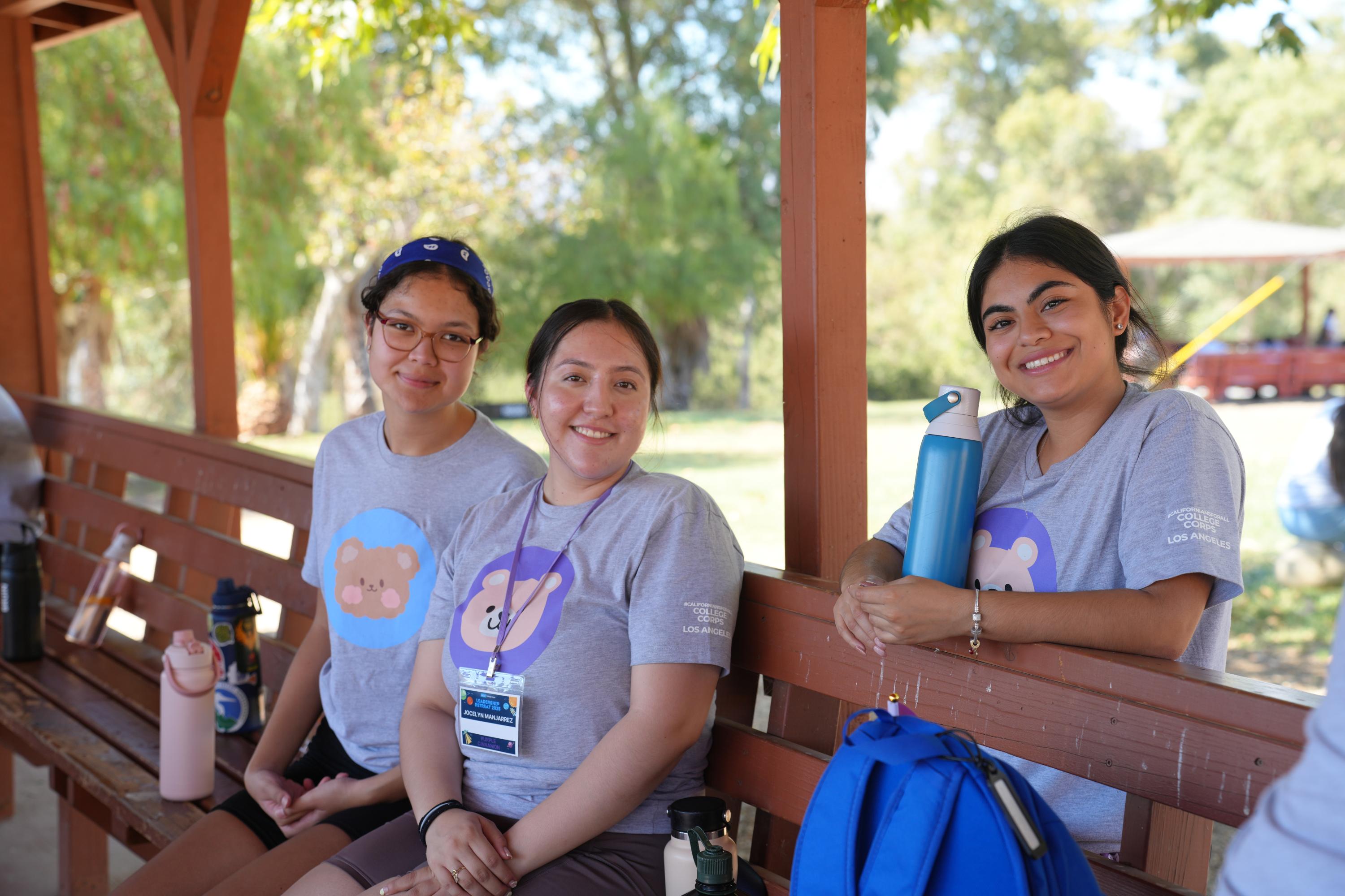Three students smiling at the camera