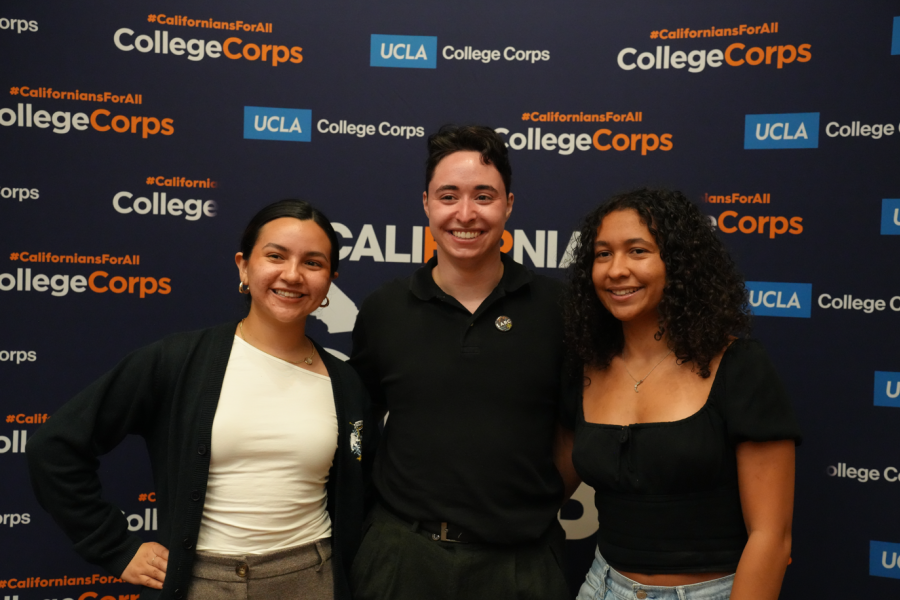 Image of three people standing together and smiling at the camera